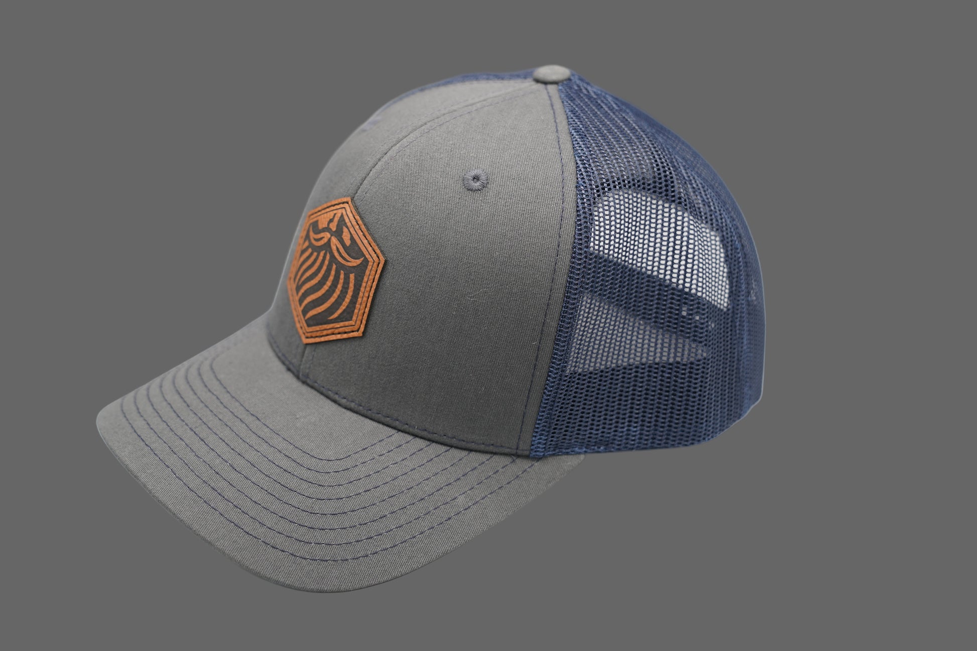 Gray and blue trucker cap with a brown logo on a white background