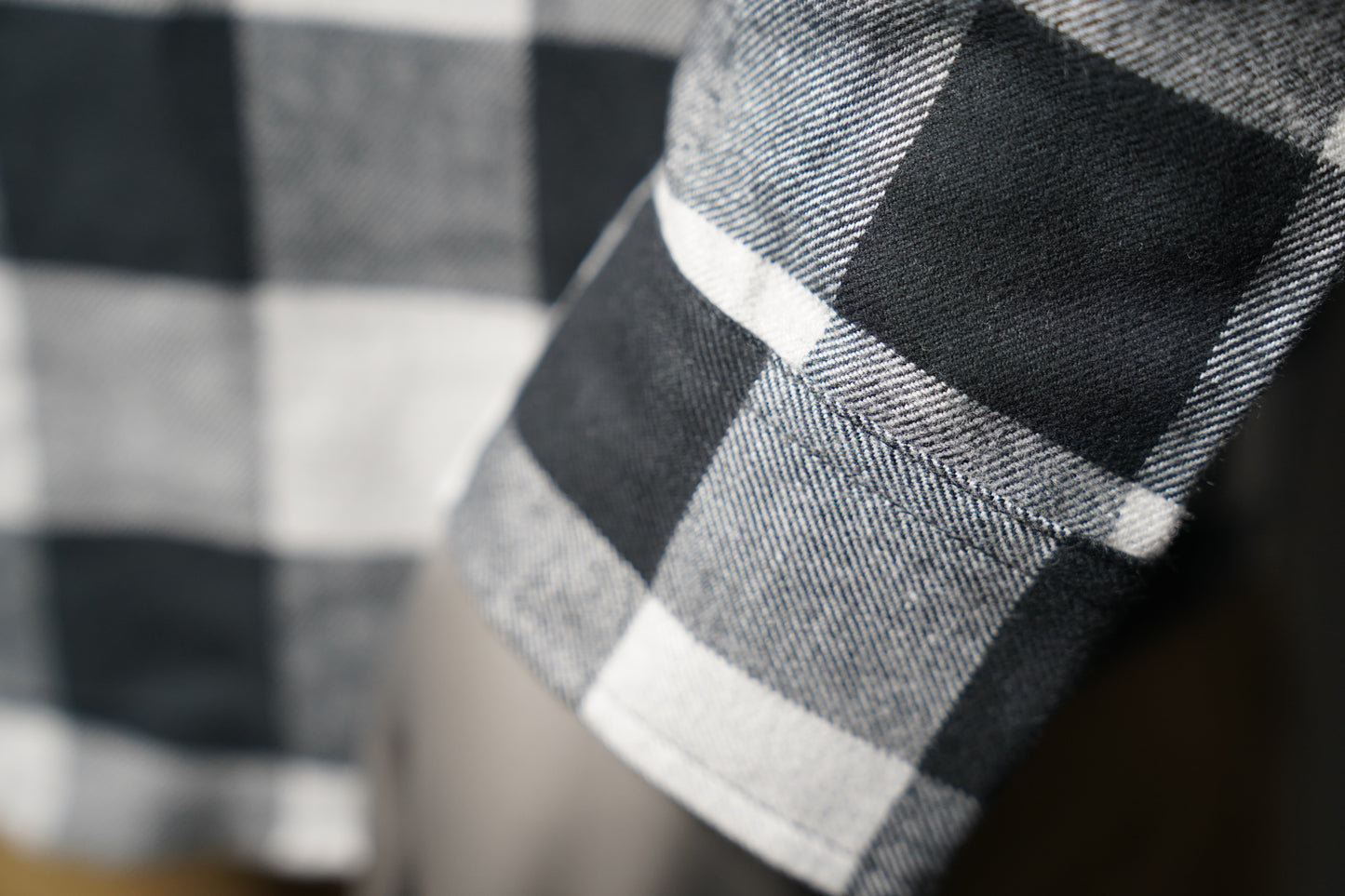 Close-up of a black and white checkered fabric sleeve with a blurred background