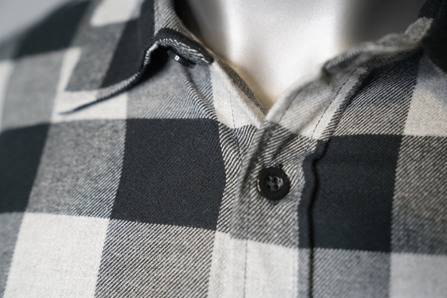 Close-up of a gray and black checkered shirt on a mannequin.