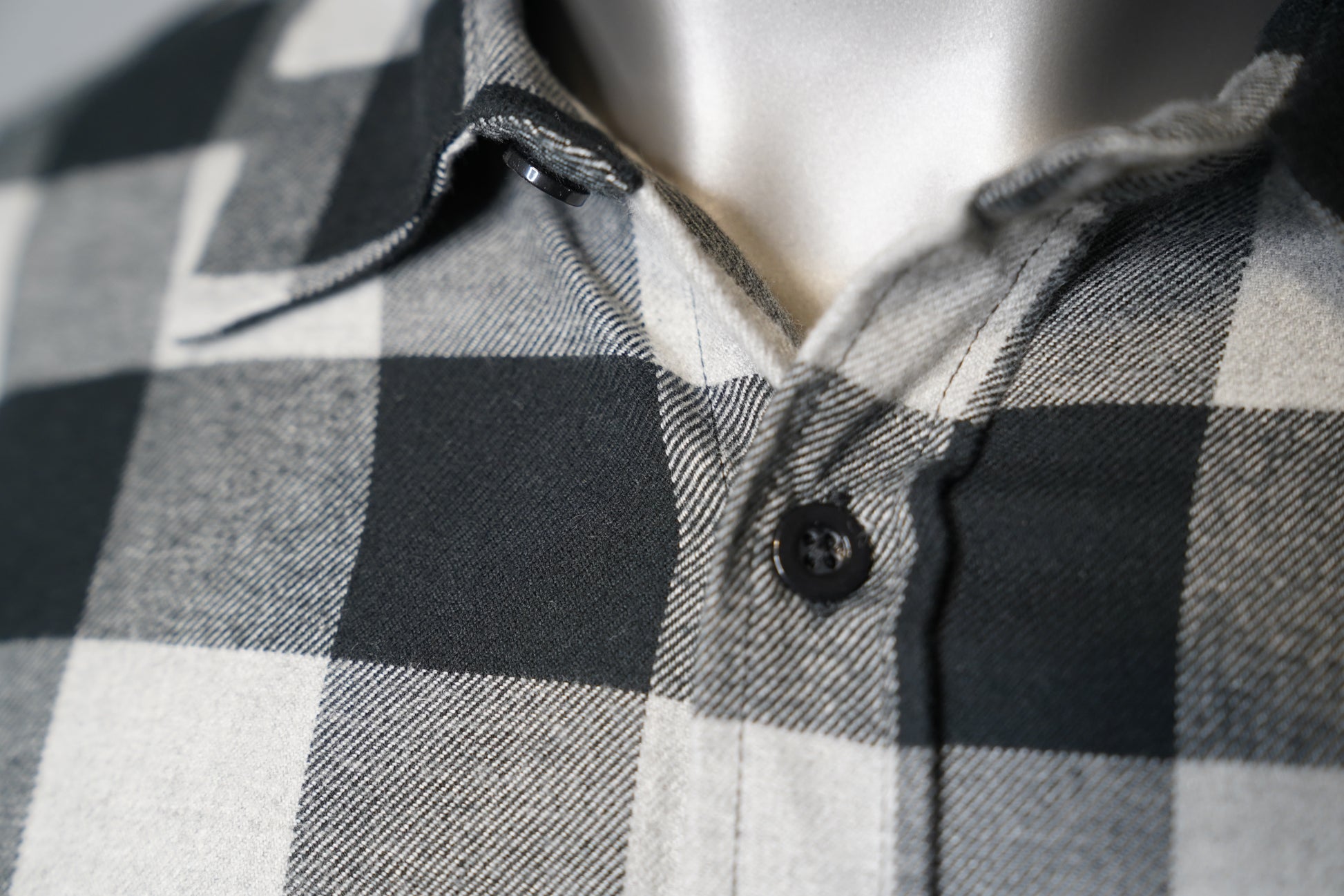 Close-up of a gray and black checkered shirt on a mannequin.
