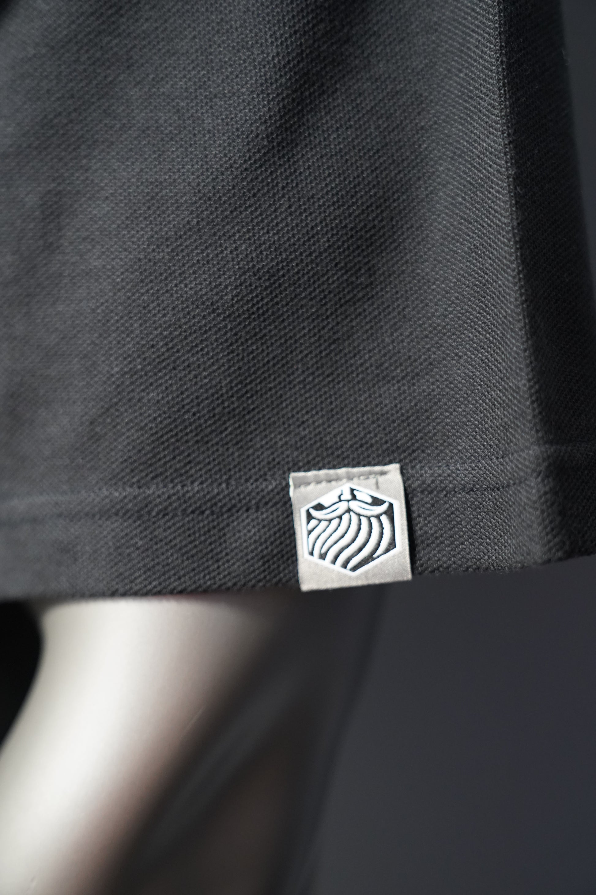 Close-up of a black garment with a brand logo