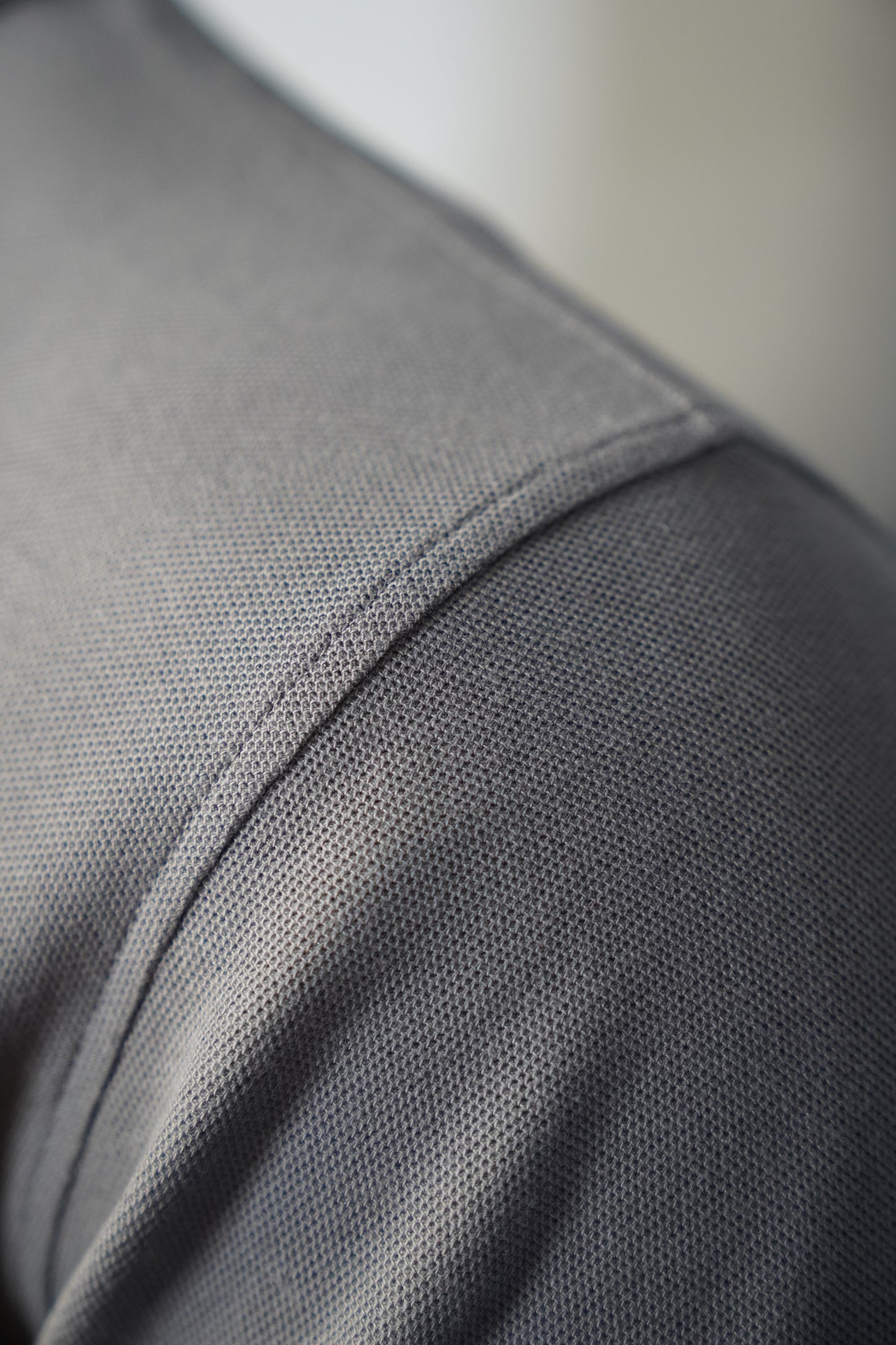 Close-up of a graphite polo shirt with stitching