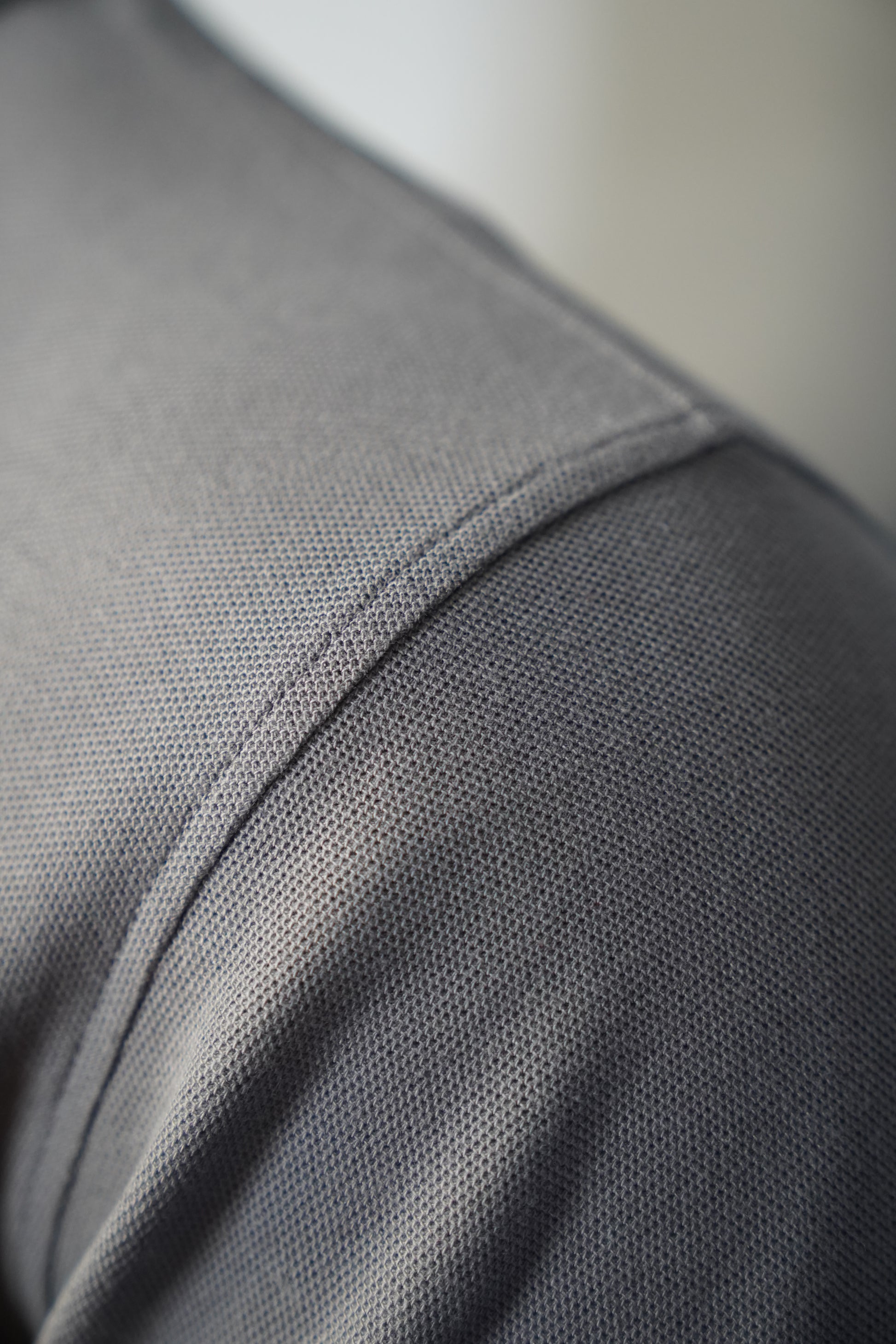 Close-up of a graphite polo shirt with stitching