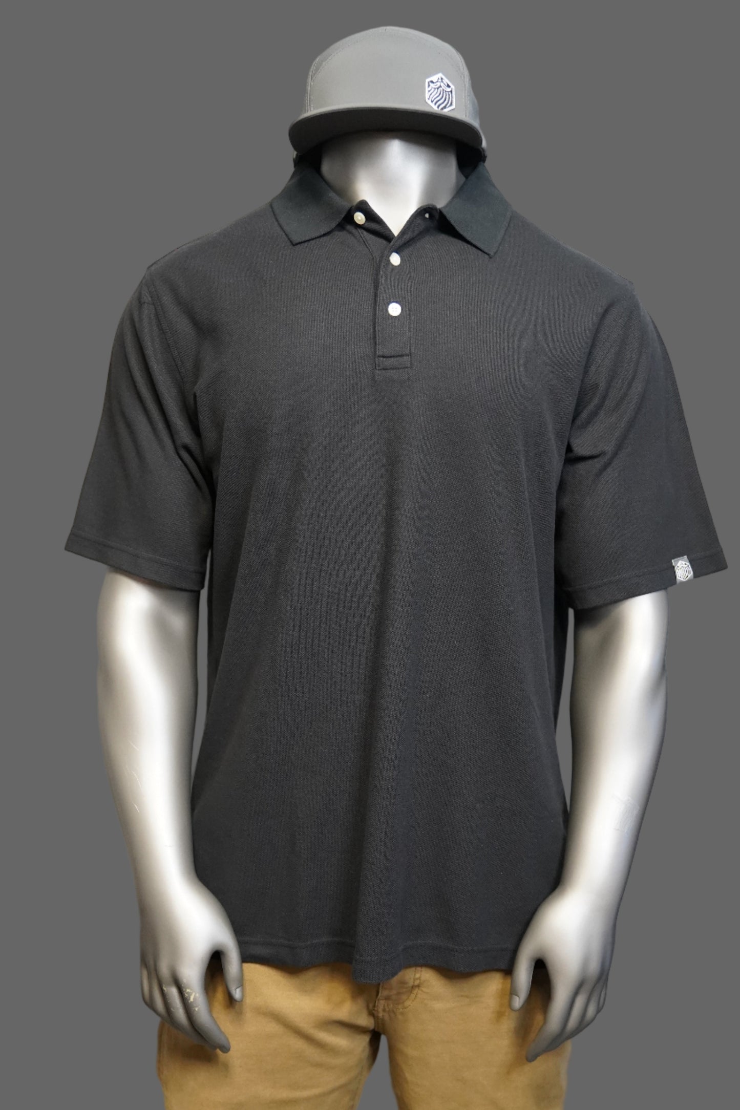 Black polo shirt against a gray background
