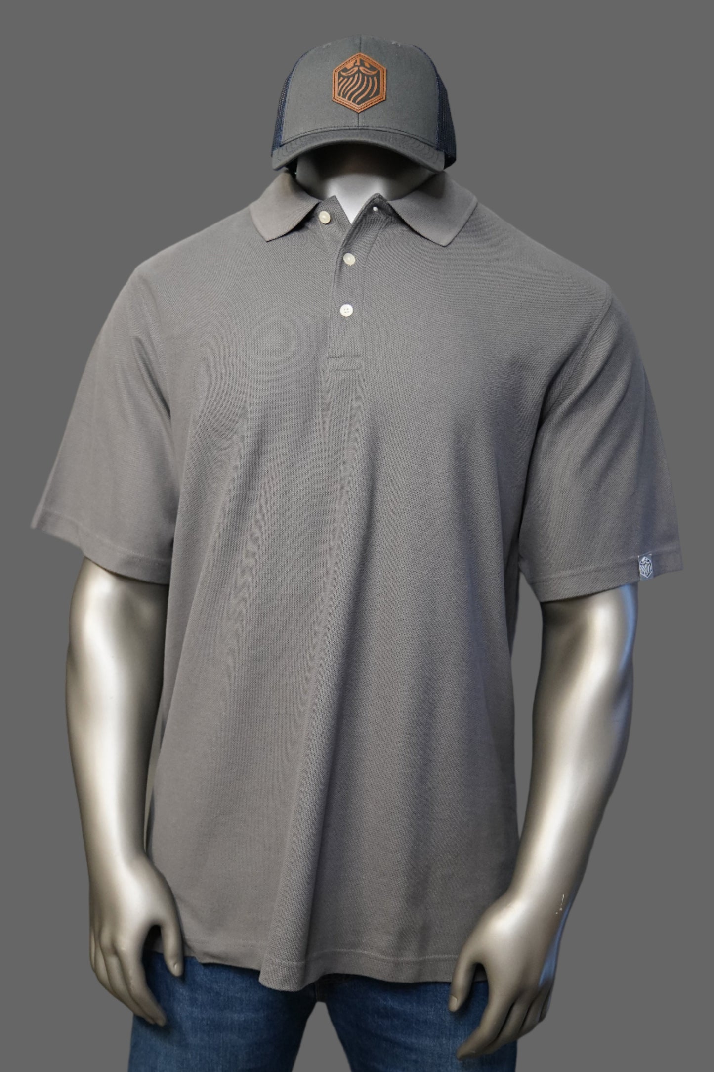 Graphite polo shirt and blue jeans on a plain background