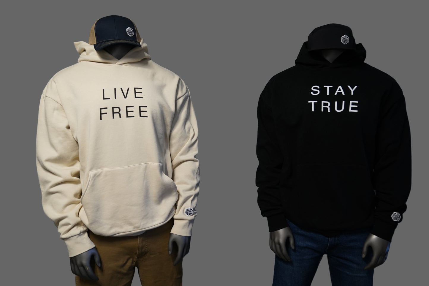 Two hoodies, one ivory with 'Live Free' text and one black with 'Stay True' text,  against a gray background.