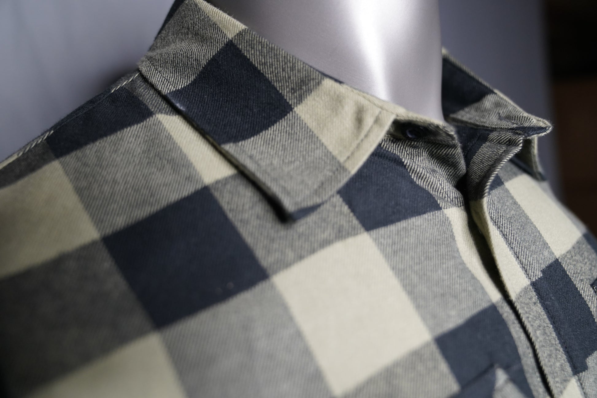 Close-up of black and olive checkered fabric texture collar