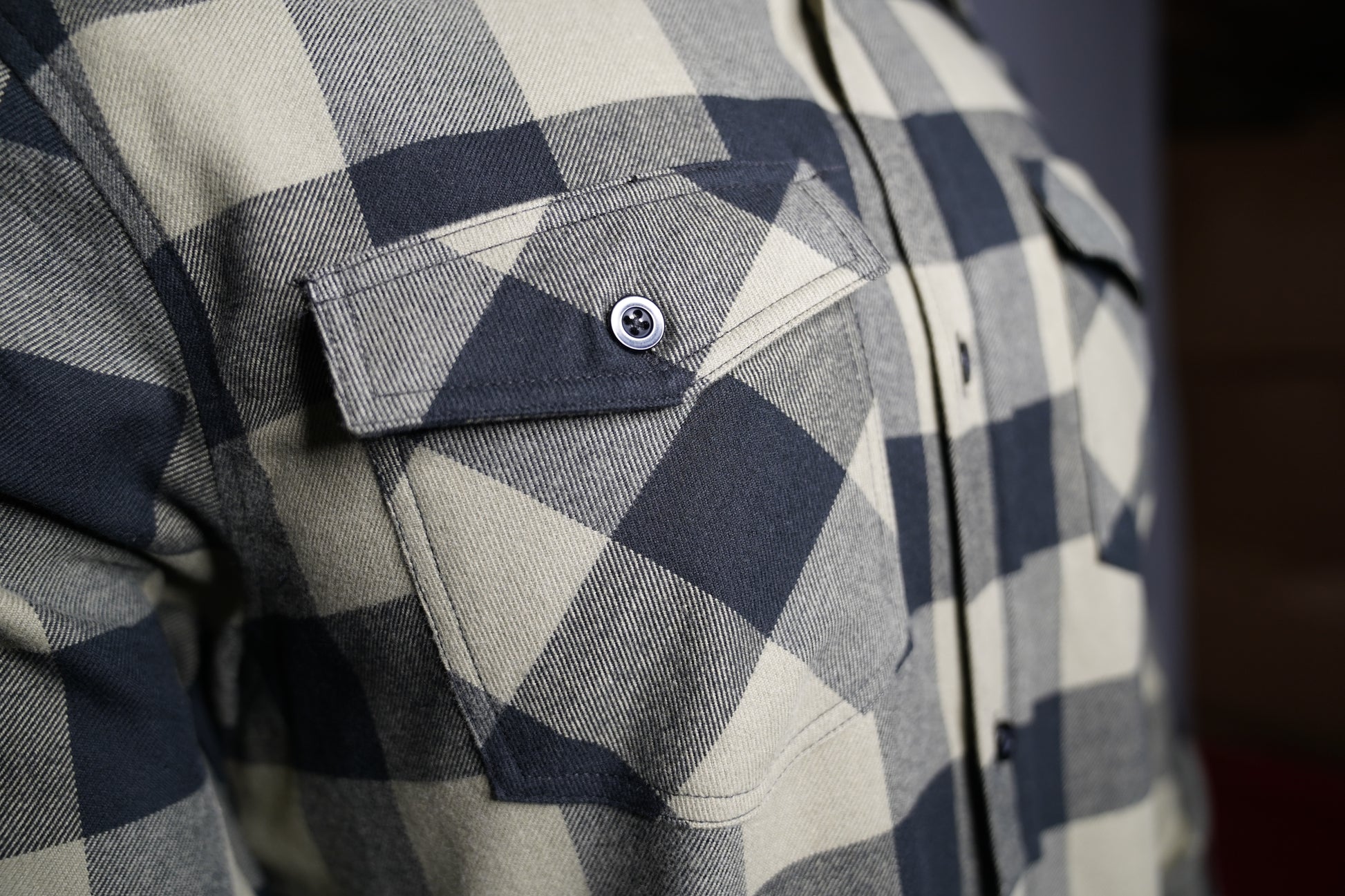 Close-up of black and olive checkered fabric texture chest pocket
