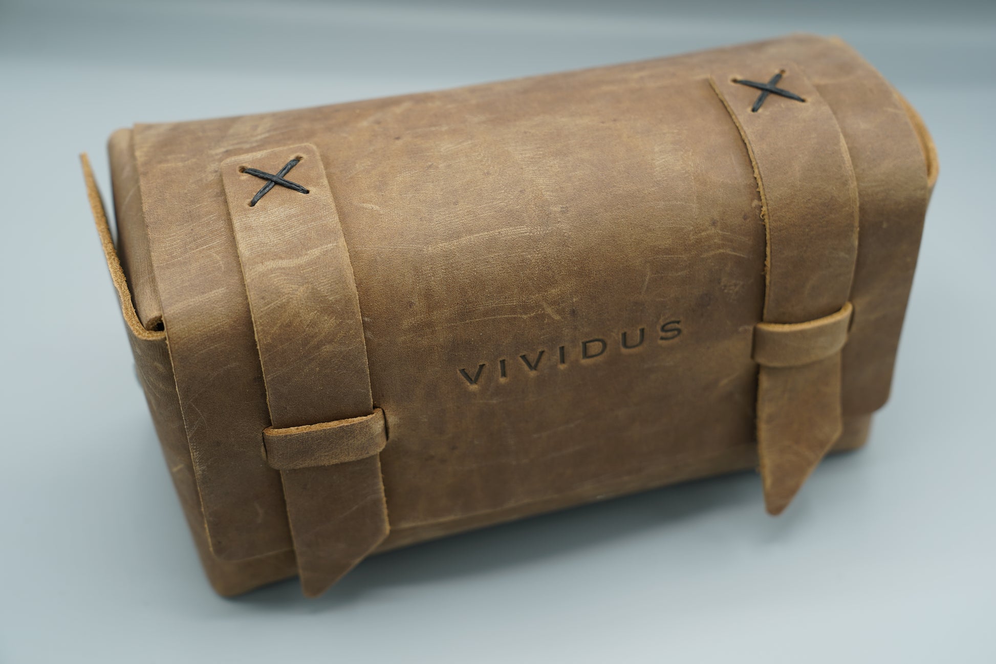 Distressed broen Leather Dopp Kit Bag roll-up bag with 'VIVIDUS' branding on a gray background
